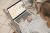 Young woman sitting on a garden chair on the balcony with a laptop on her legs showing a whiteboard for agile management.