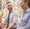 3 people from consultant community of conceptboard laughing outside and having a laptop in the hands