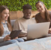 3 students looking in a laptop and using conceptboard for their studies