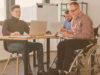 3 people working digitally with an online collaboration tool. One person is sitting in a wheelchair. Conceptboard is available for everyone with special needs