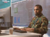 Person from defence industry in front of of a computer using a secure online collaboration tool