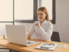 A doctor from Pharma and healthcare industry is sitting at a desk and working on the laptop on a secure collaboration tool