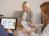 Three People working remotely using Conceptboard. One person work on a board on the laptop, while the other person works on a board on the iPad