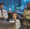 3 people from defence industry work together in front of a laptop. They are responsible for secure collaboration by using a secure whiteboard software