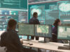 one person working a top secret organisation in front of of many screens with coding on them
